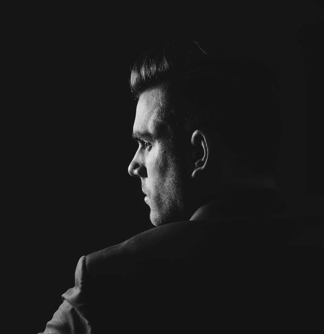 Self-made billionaire looking out in a dark room