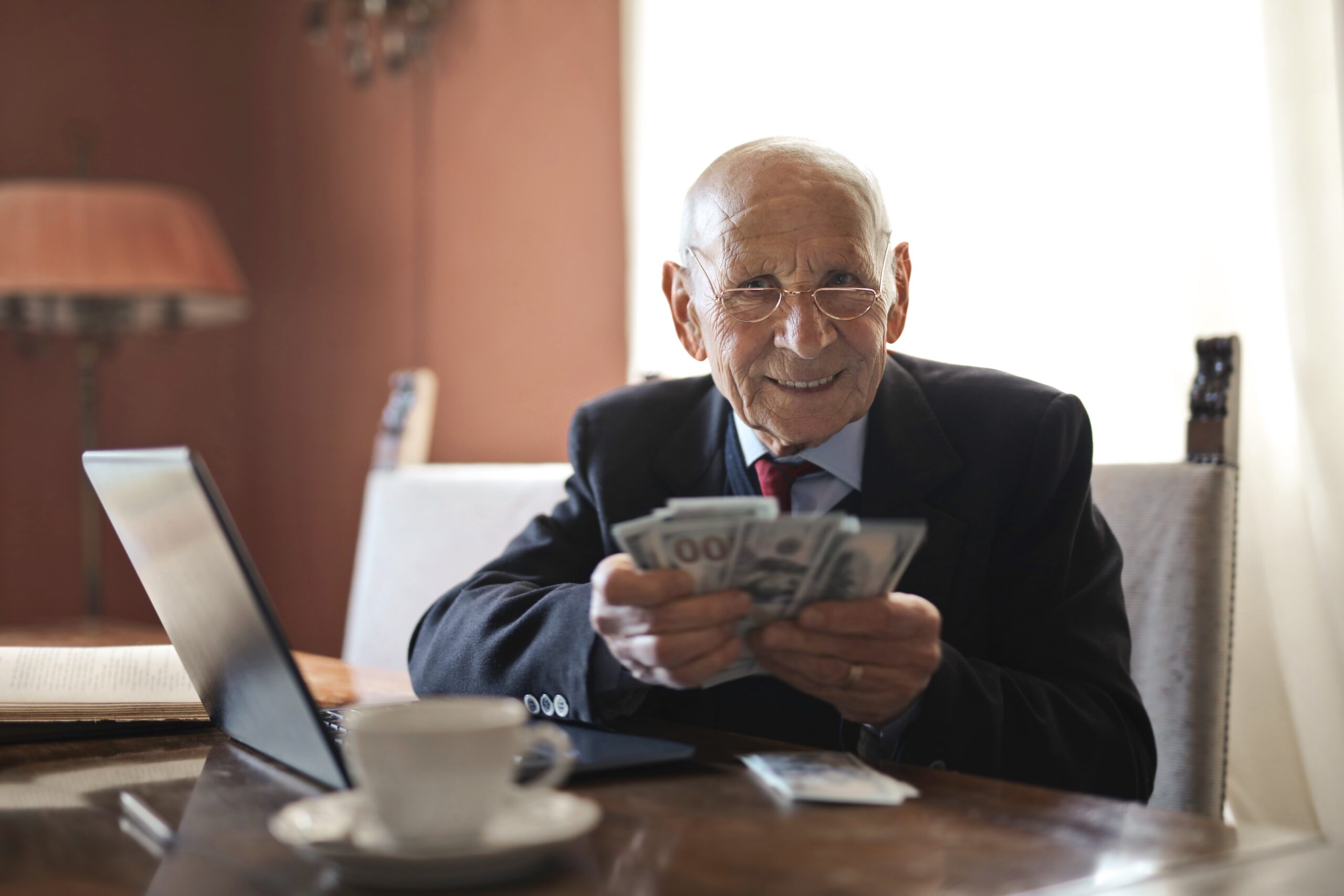 An old aged investor holding cash, showing the outcome of diversifying his portfolio