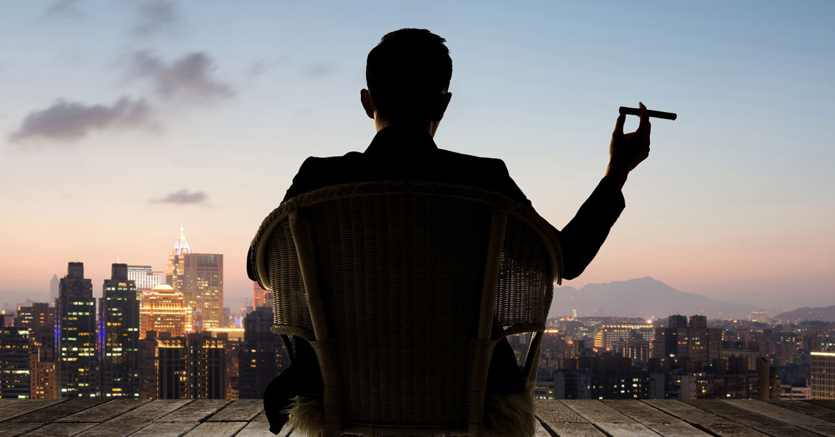A wealthy Investor relaxing outside his penthouse with a cigar
